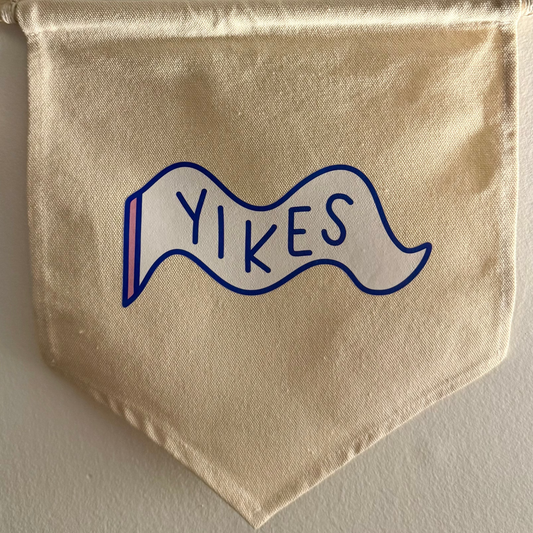 Beige banner with 'Yikes' text on a white wall